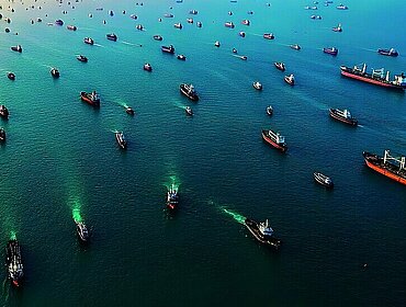 Luftaufnahme: Viele Frachtschiffe im Ozean zeigen den regen globalen Handel und maritime Lieferketten.