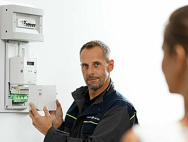 Mitarbeiter von Wiener Netze installiert ein Smart Meter bei einer Kundin